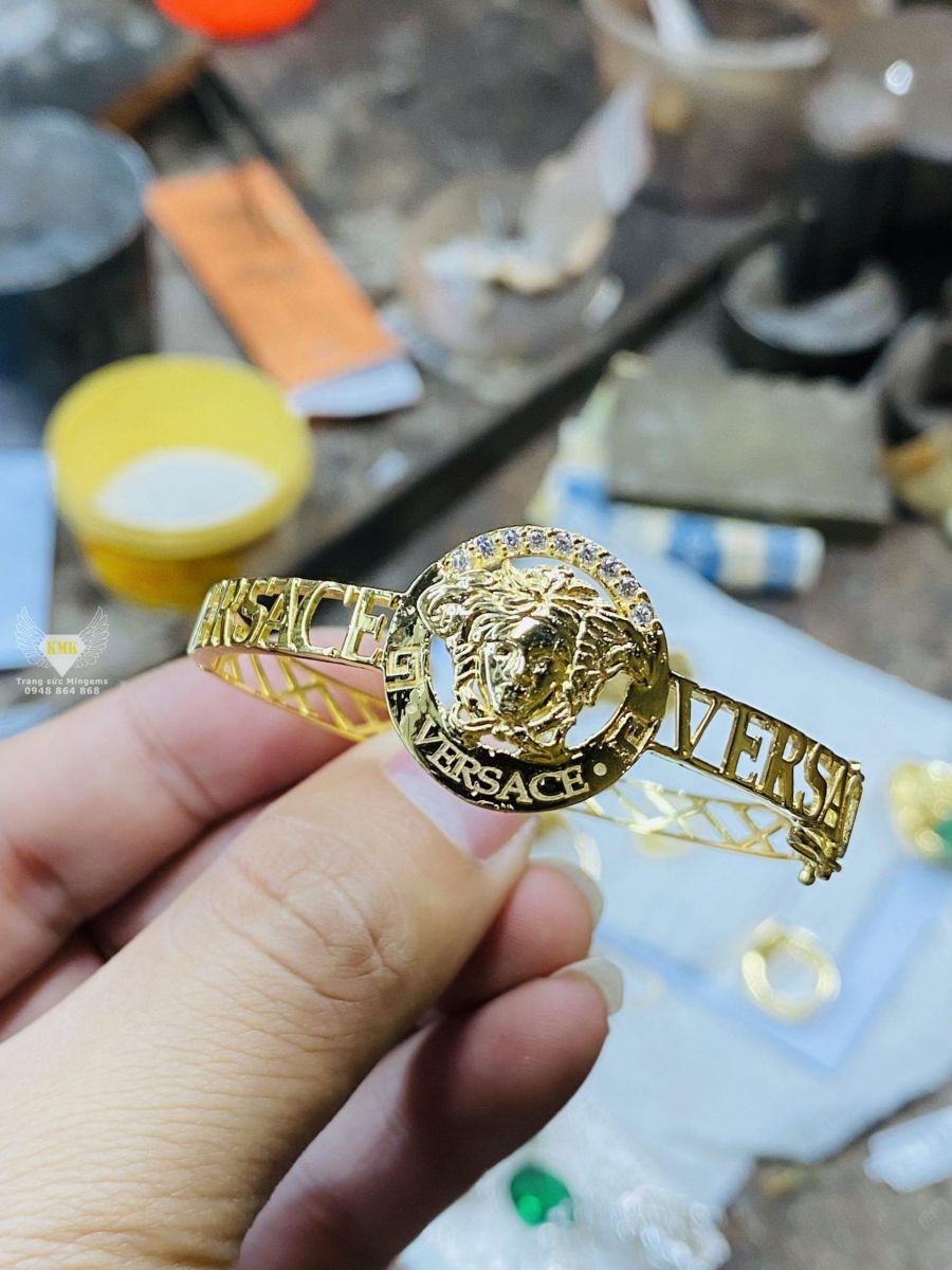 Vòng tay Versace vàng 18K siêu nhẹ - Vàng đính xoàn tấm: Đây là chiếc vòng tay được chế tác từ chất liệu vàng 18K cùng kim cương tự nhiên rực rỡ. Với thiết kế siêu nhẹ và nữ tính, mang chiếc vòng này sẽ giúp bạn tự tin thể hiện cá tính riêng của mình.